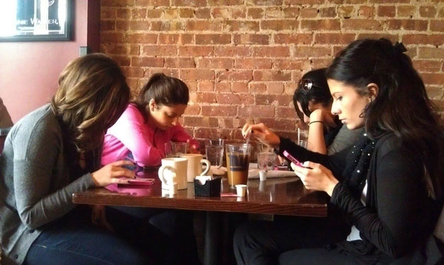 Old friends gather on a brunch but spend time on mobile phone