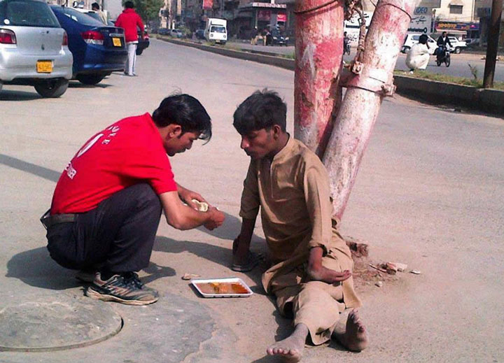 The owner of a shop that leaves his work to feed a disabled in the street-Emotional Charged Photographs That Prove That Humanity Is Not Yet Lost-9
