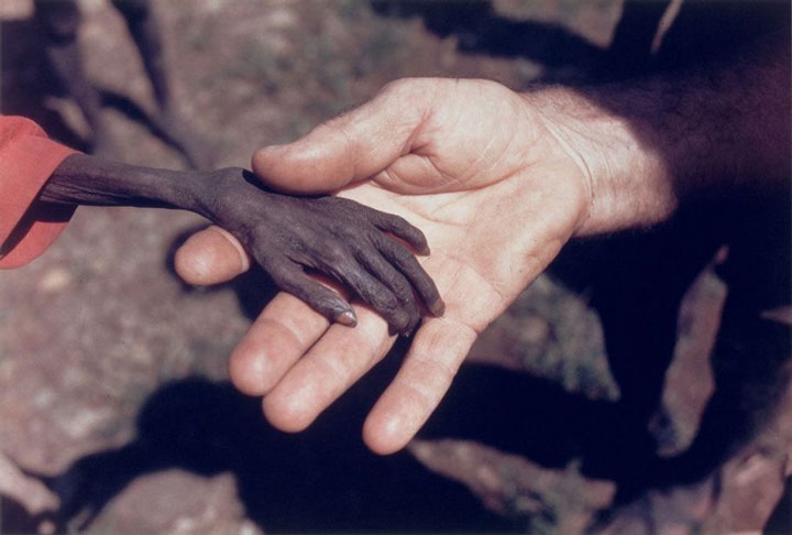 A hungry little boy gives his hand to a missionary-Most Touching Photographs-2