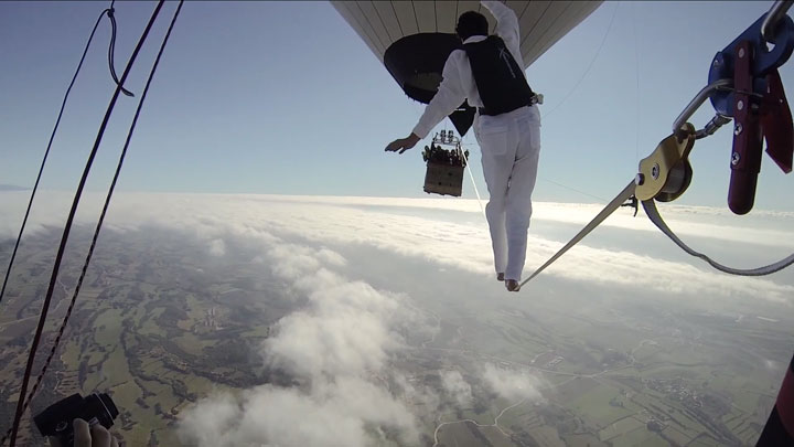 Amazing Stunt Of Walking On A Tightrope Between Two Air Balloons Above Clouds-